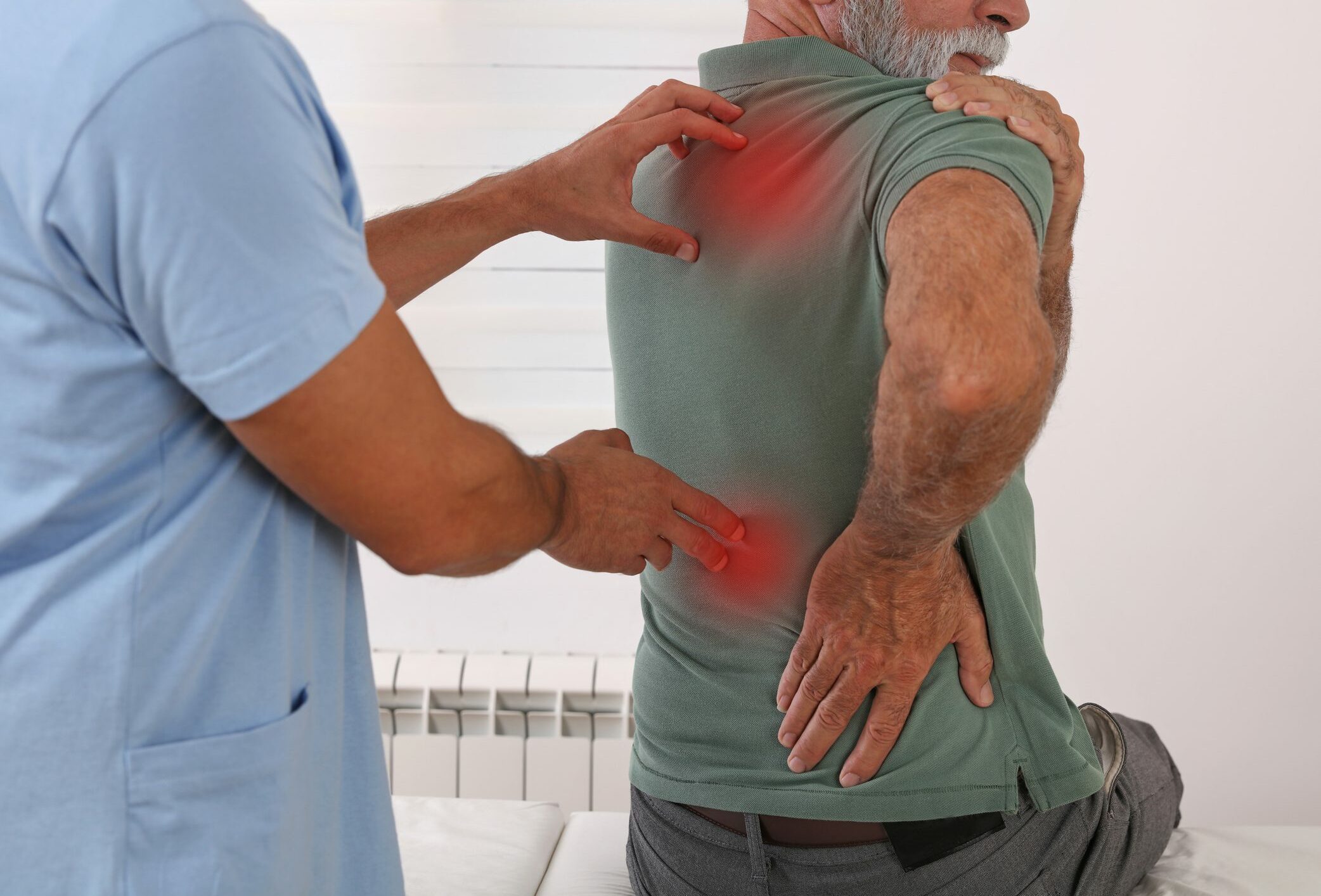 Senior man with back pain. Spine physical therapist and paient. Chiropractic pain relief therapy.